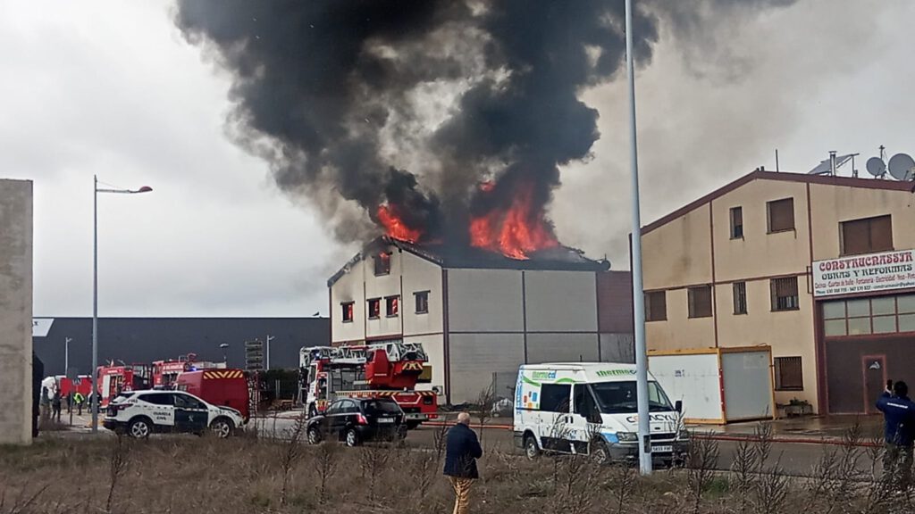 Las llamas devoran el tejado del inmueble situado en el polígono industrial de Lerma. Alfredo Alonso