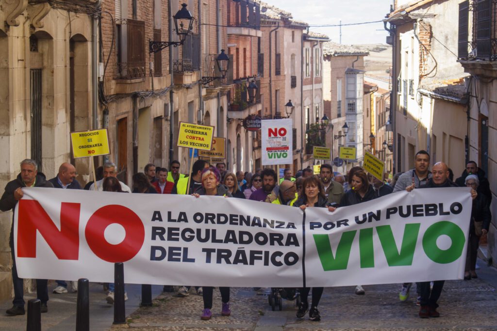 Los manifestantes suben por la Calle Mayor con una pancarta al frente